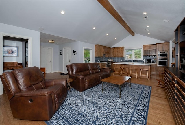 living room with light hardwood / wood-style flooring and lofted ceiling with beams