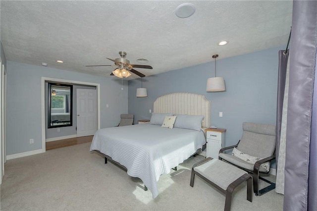 bedroom with light carpet, a textured ceiling, and ceiling fan