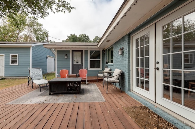 wooden deck with french doors and an outdoor fire pit