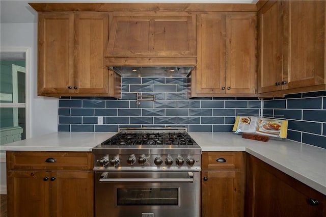 kitchen with high end range, backsplash, and premium range hood