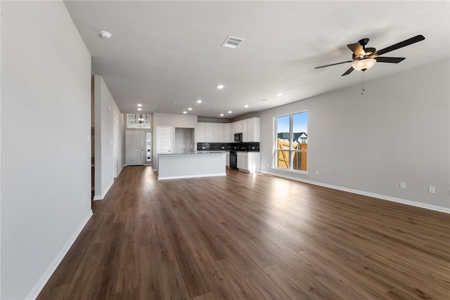 unfurnished living room with dark hardwood / wood-style flooring and ceiling fan