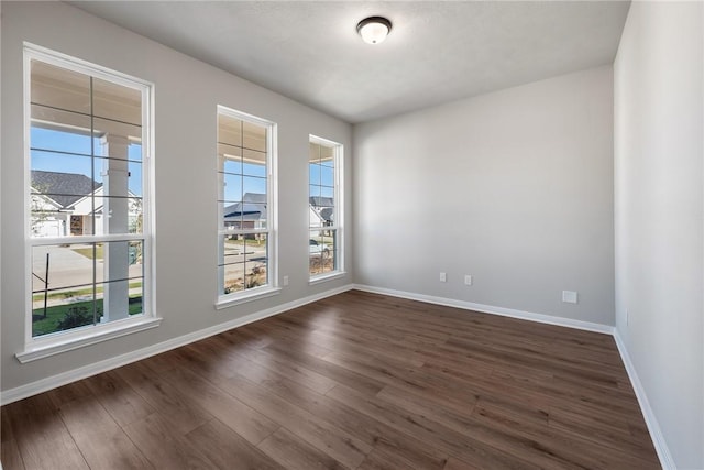 unfurnished room with dark wood-type flooring