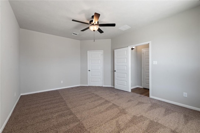 unfurnished bedroom featuring dark colored carpet, a closet, and ceiling fan