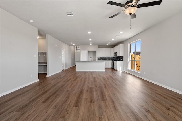 unfurnished living room with ceiling fan and dark hardwood / wood-style floors