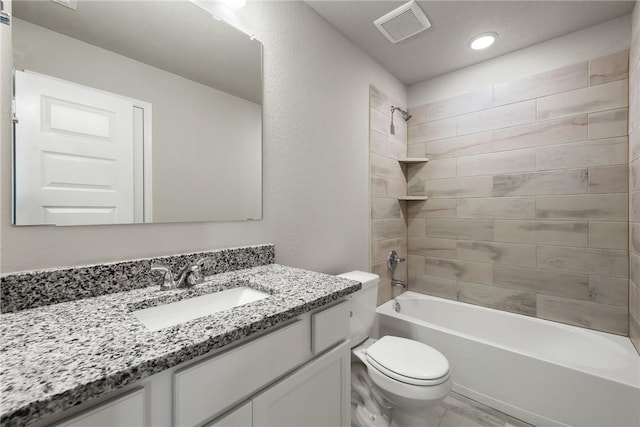 full bathroom featuring tiled shower / bath combo, toilet, and vanity