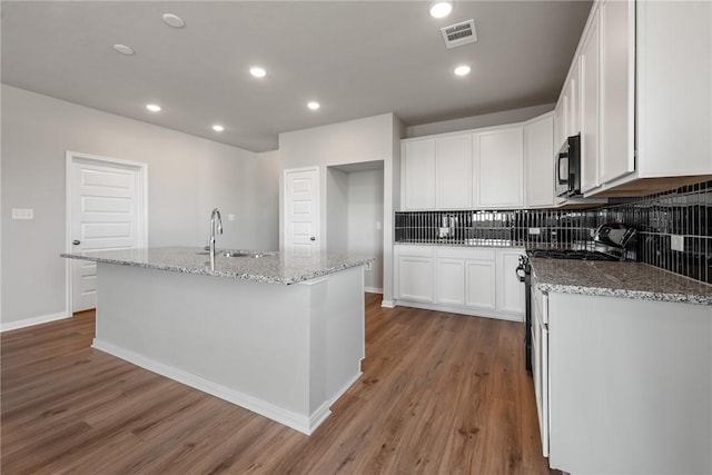 kitchen with white cabinetry, a kitchen island with sink, and appliances with stainless steel finishes