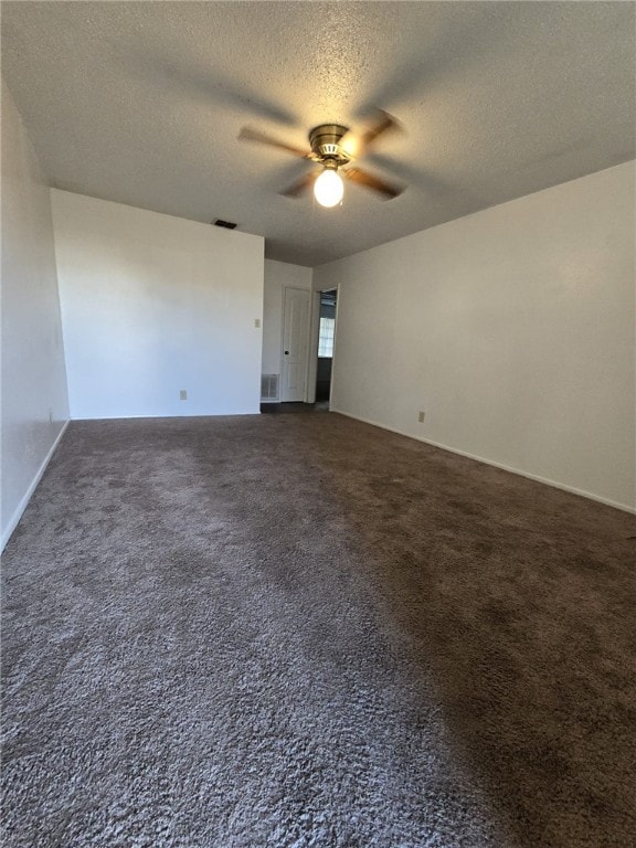 carpeted spare room with ceiling fan and a textured ceiling