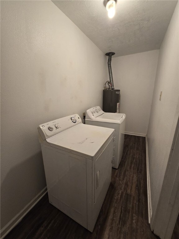 clothes washing area featuring dark hardwood / wood-style flooring, electric water heater, a textured ceiling, and washing machine and clothes dryer