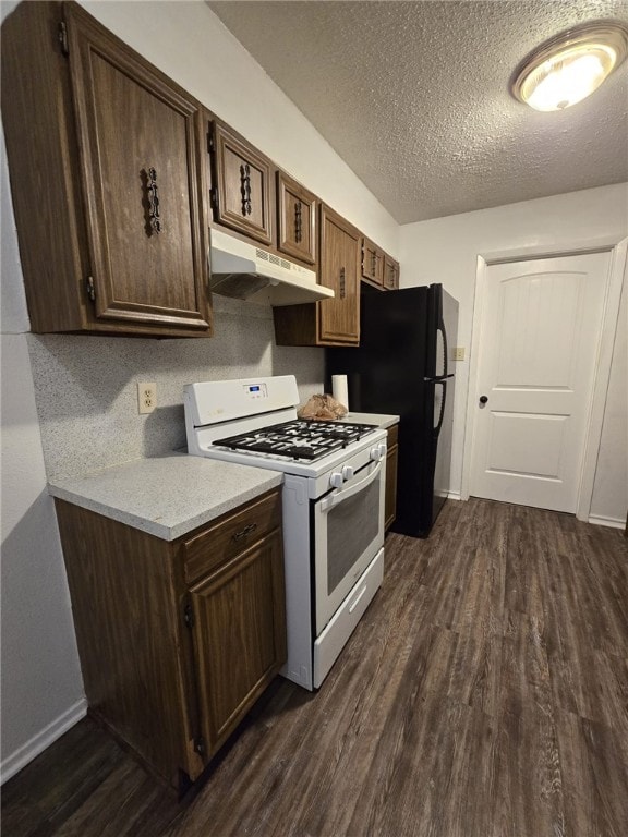 kitchen with dark wood-type flooring, white range with gas stovetop, black refrigerator, a textured ceiling, and dark brown cabinetry