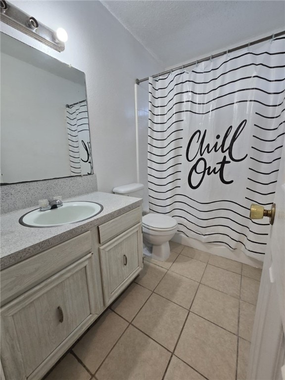 full bathroom with tile patterned floors, shower / bath combination with curtain, a textured ceiling, toilet, and vanity