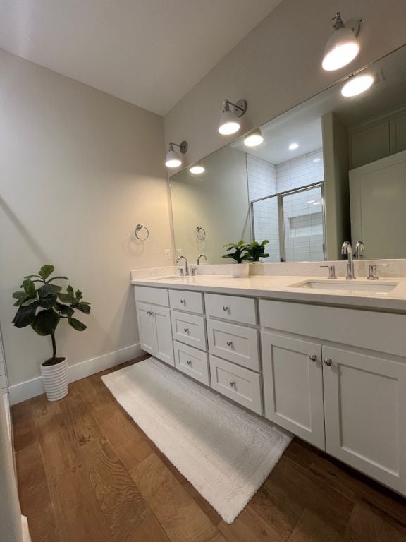 2016 R A Galindo Blvd, Bryan, TX 77807 - full bath with wood finished floors, a shower stall, double vanity, and baseboards