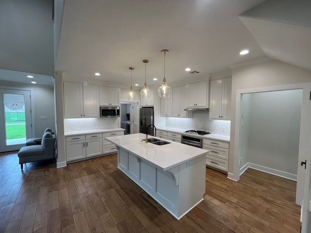 2016 R A Galindo Blvd, Bryan, TX 77807 - kitchen with stainless steel microwave, black fridge with ice dispenser, a sink, white cabinetry, and dark wood finished floors