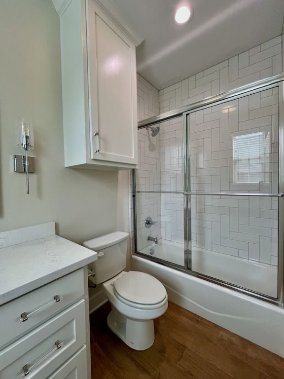 2016 R A Galindo Blvd, Bryan, TX 77807 - full bath with wood finished floors, vanity, enclosed tub / shower combo, toilet, and recessed lighting