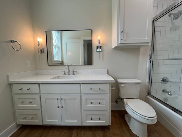 2016 R A Galindo Blvd, Bryan, TX 77807 - bathroom with wood finished floors, baseboards, toilet, vanity, and enclosed tub / shower combo