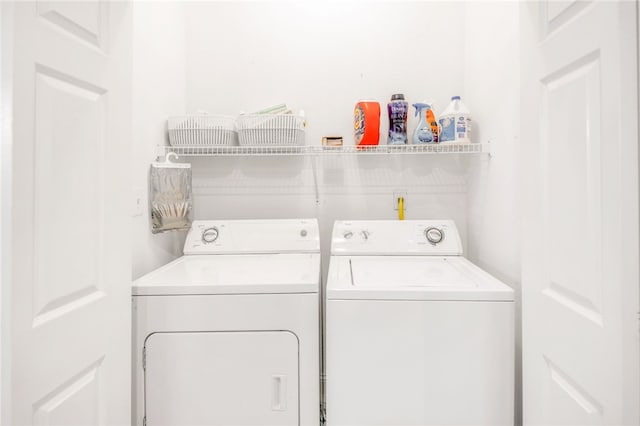 clothes washing area featuring separate washer and dryer and laundry area