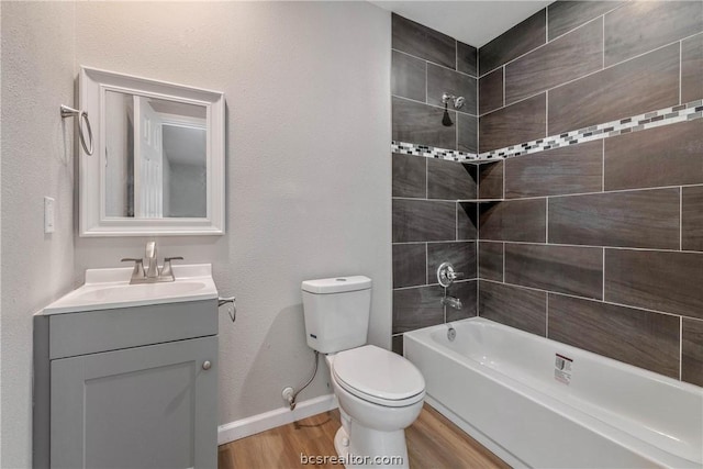 full bathroom with vanity, wood-type flooring, tiled shower / bath combo, and toilet