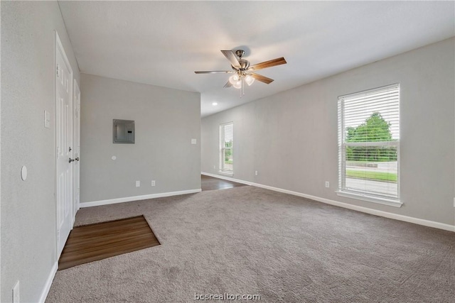 carpeted spare room featuring electric panel and ceiling fan