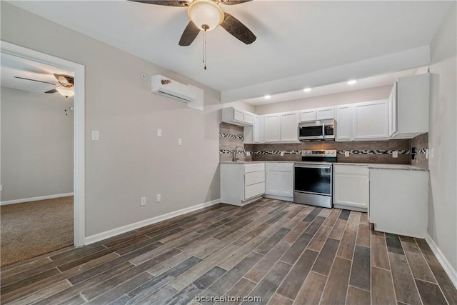 kitchen featuring an AC wall unit, white cabinetry, dark wood-type flooring, and appliances with stainless steel finishes