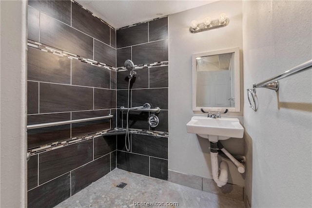 bathroom featuring a tile shower and sink