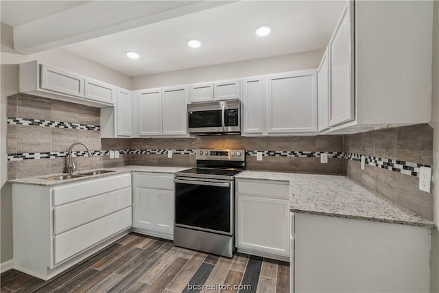 kitchen featuring white cabinetry, sink, dark wood-type flooring, and appliances with stainless steel finishes