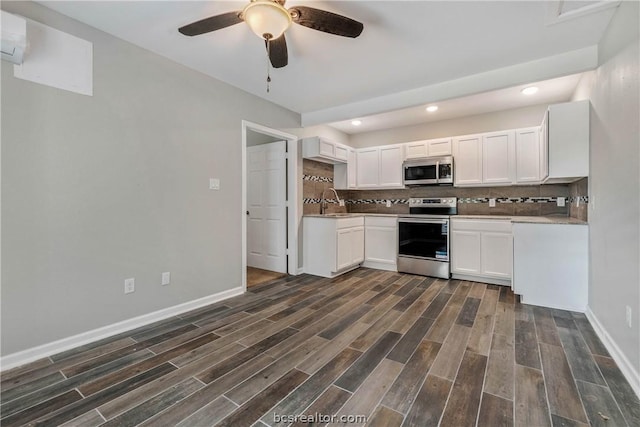 kitchen with backsplash, stainless steel appliances, ceiling fan, dark wood-type flooring, and white cabinetry