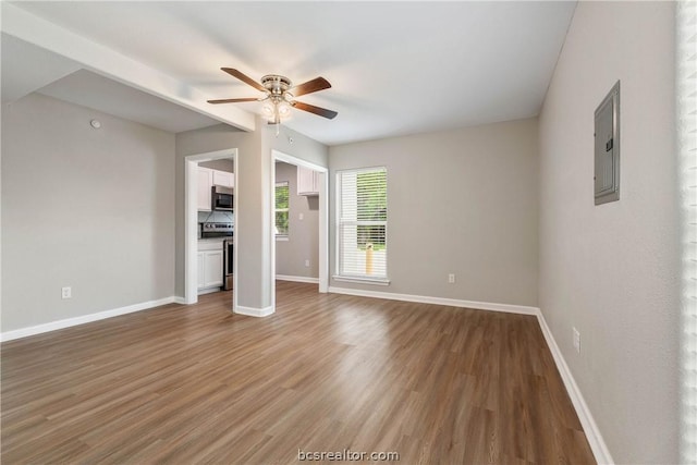 unfurnished living room with wood-type flooring, electric panel, and ceiling fan