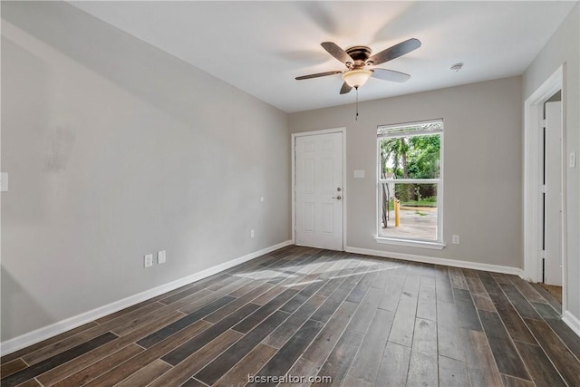 empty room with dark hardwood / wood-style flooring and ceiling fan