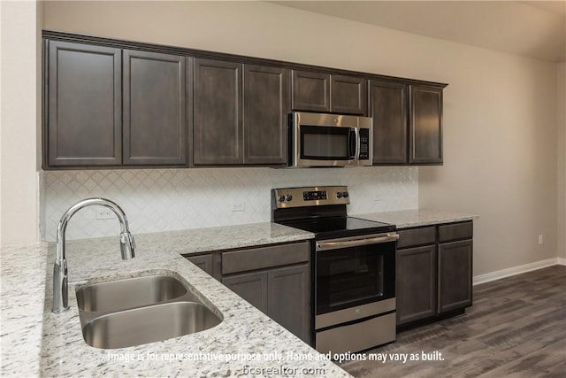 kitchen with dark hardwood / wood-style flooring, light stone counters, dark brown cabinetry, stainless steel appliances, and sink