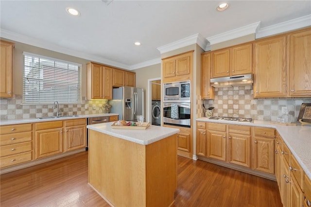 1605 Dominik Dr, College Station, TX 77840 - kitchen with appliances with stainless steel finishes, a sink, under cabinet range hood, light wood finished floors, and light countertops