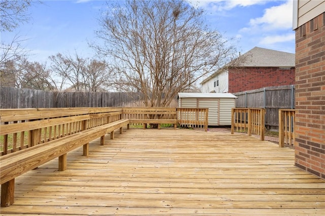 deck with an outbuilding, a storage unit, and fence