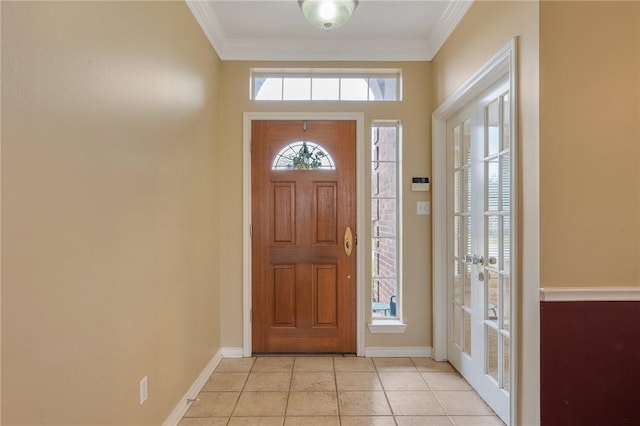 entrance foyer with light tile patterned floors, baseboards, and crown molding