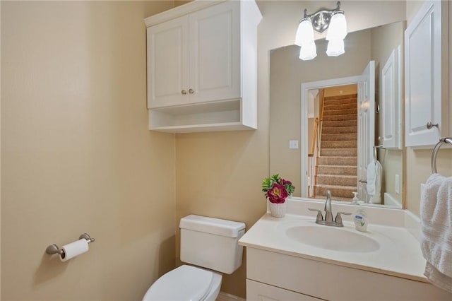 bathroom with vanity, toilet, and an inviting chandelier