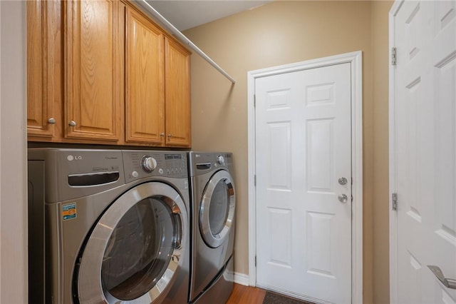 clothes washing area featuring washing machine and clothes dryer and cabinet space