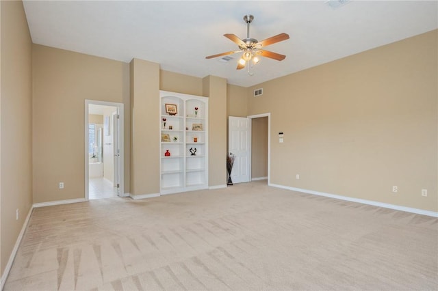 empty room with light carpet, ceiling fan, visible vents, and baseboards