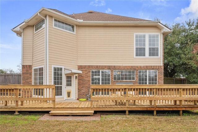 back of house featuring brick siding, fence, and a wooden deck