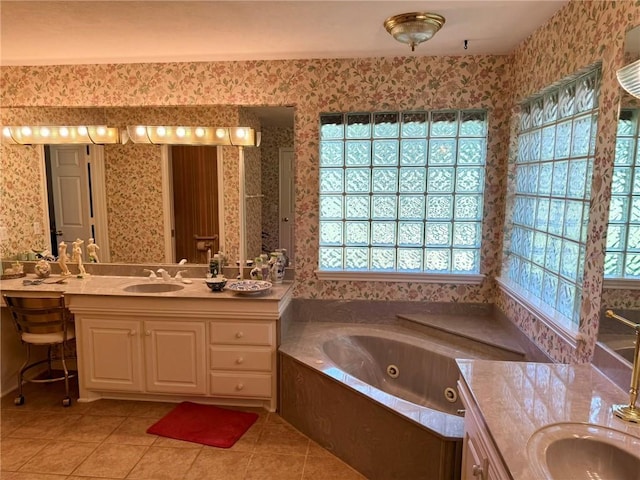 40 Casper Pl, Hilltop Lakes, TX 77871 - bathroom featuring wallpapered walls, healthy amount of natural light, tile patterned floors, a tub with jets, and vanity