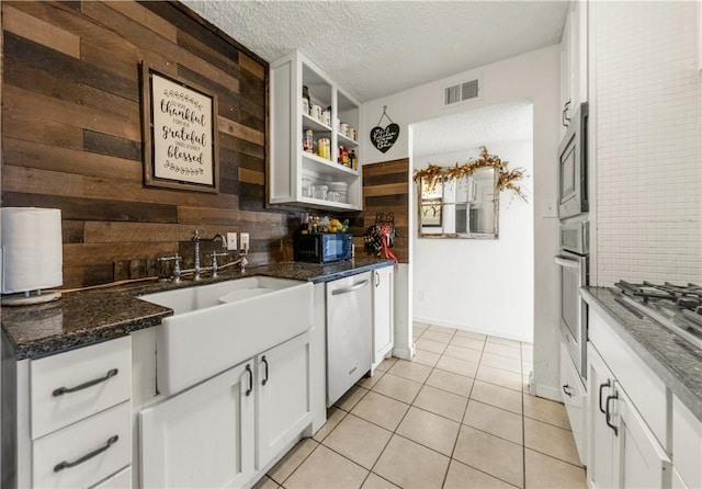 kitchen featuring backsplash, appliances with stainless steel finishes, white cabinetry, and a textured ceiling