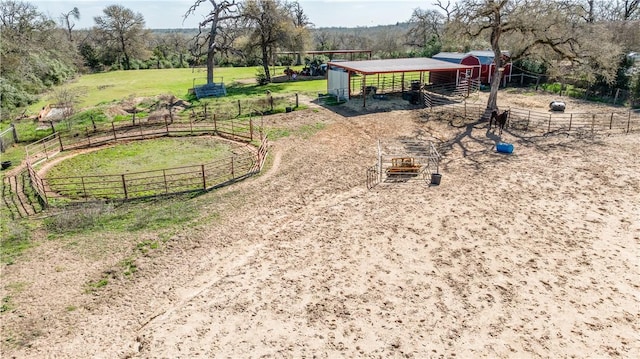 exterior space featuring a rural view, an exterior structure, an enclosed area, and an outdoor structure