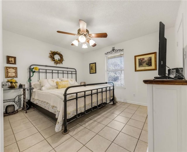 bedroom featuring light tile patterned floors, a ceiling fan, baseboards, and a textured ceiling