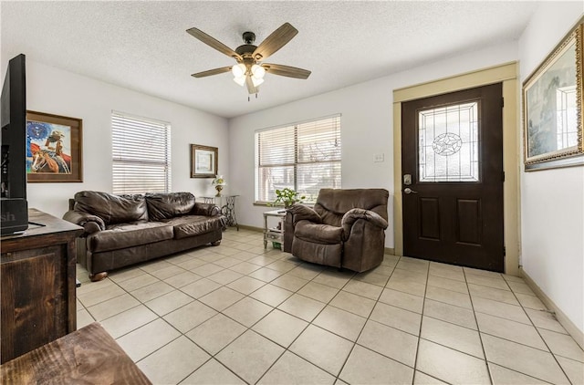 living area with light tile patterned floors, a textured ceiling, and a ceiling fan