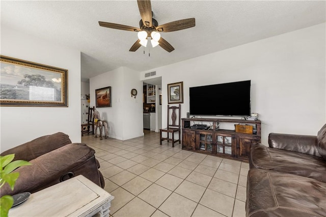 living room with light tile patterned flooring, visible vents, a textured ceiling, and a ceiling fan