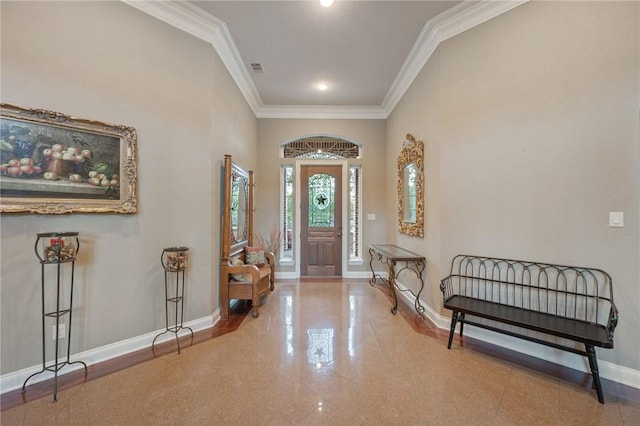 foyer with a towering ceiling and crown molding