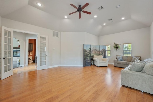 living room with ceiling fan, french doors, high vaulted ceiling, and light hardwood / wood-style flooring