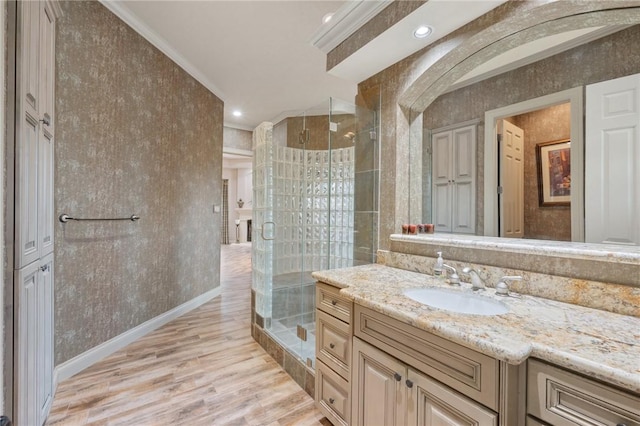 bathroom featuring hardwood / wood-style floors, vanity, an enclosed shower, and crown molding