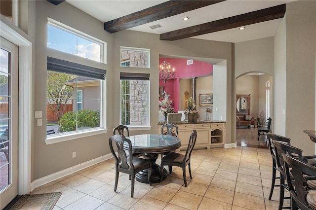 tiled dining area featuring beamed ceiling and an inviting chandelier