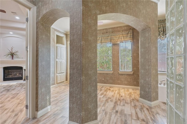 bathroom featuring a bathing tub, crown molding, and wood-type flooring