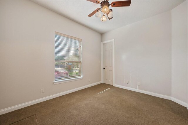 carpeted spare room featuring ceiling fan