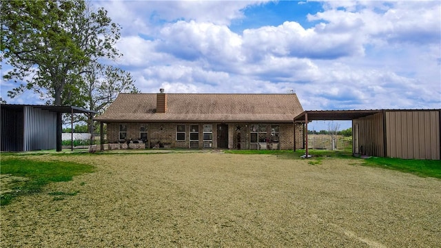 7523 State Highway 21 W, Caldwell, TX 77836 - rear view of house featuring a chimney, an outbuilding, brick siding, a pole building, and driveway