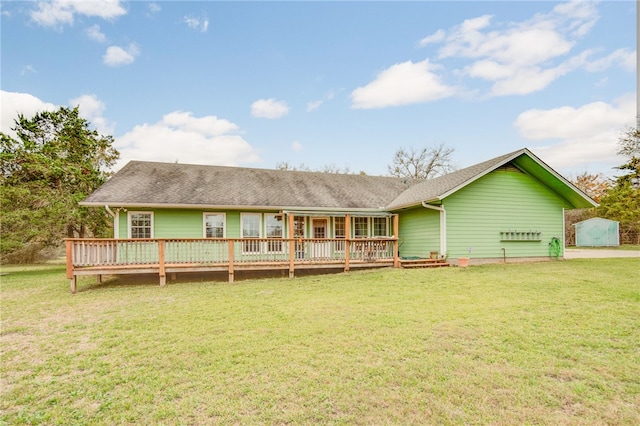 back of house with a storage unit, an outbuilding, a lawn, and a wooden deck