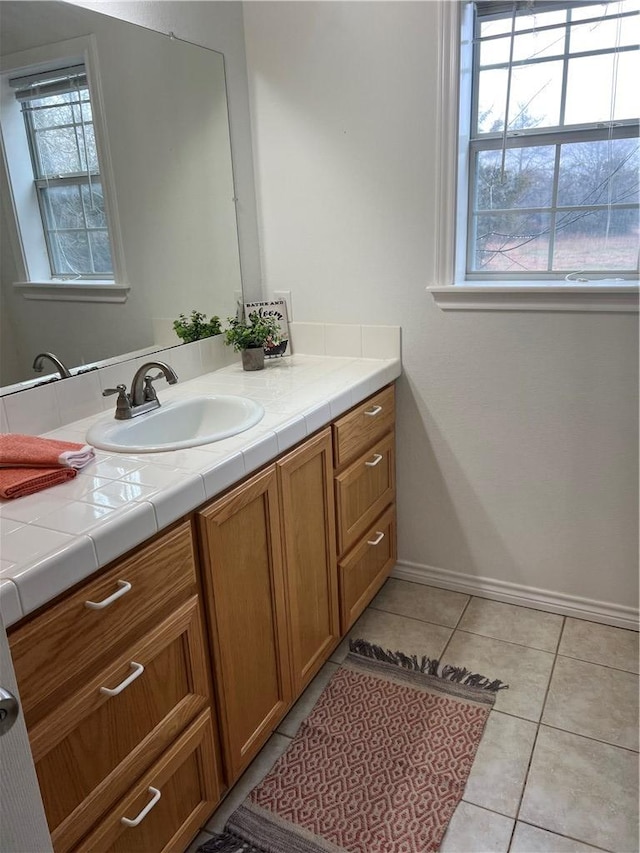 bathroom featuring vanity, baseboards, and tile patterned floors